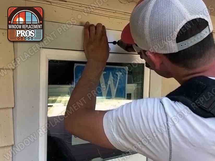 Window Replacement Pros installer securing the trim on a newly installed window