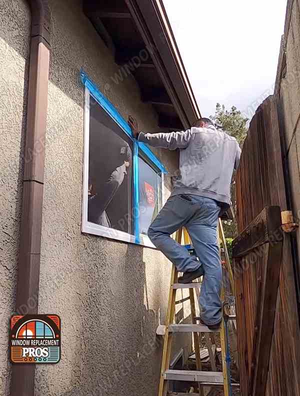 Installer removing a large window insert from a home during a replacement